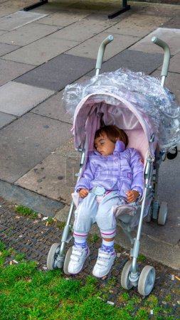 Photo for A young girl sleeping in the stroller. - Royalty Free Image