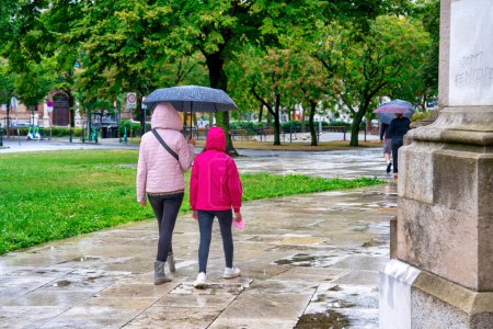 Téléchargez les photos : Promenade en plein air avec le parapluie un jour de pluie, vue arrière des gens. - en image libre de droit