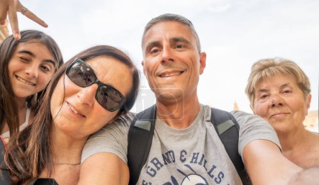 Téléchargez les photos : Une famille de quatre personnes prenant des selfies en plein air lors d'un voyage. - en image libre de droit