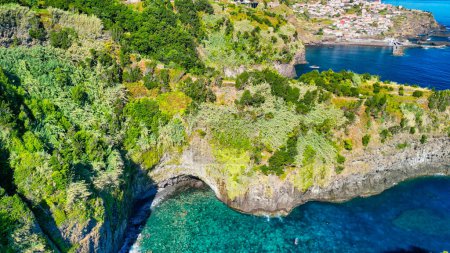 Beautiful wild coast scenery view with Bridal Veil Falls (Veu da noiva) at Ponta do Poiso in Madeira Island. Aerial view.