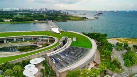 Téléchargez les photos : Singapour - 13 septembre 2023 : Vue aérienne du paysage urbain et du littoral de Marina Barrage par un après-midi couvert. - en image libre de droit