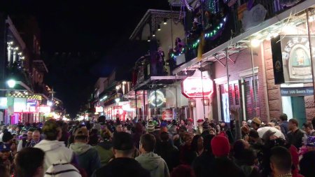 Foto de New Orleans, LA - February 9, 2016: Crowd of tourists and locals along the city streets at night for Mardi Gras event. - Imagen libre de derechos