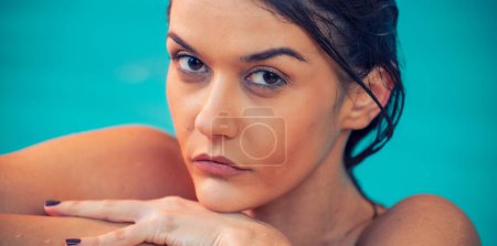 Téléchargez les photos : Belle fille caucasienne se détendre dans un spa, regardant vers la caméra, piscine en arrière-plan. - en image libre de droit