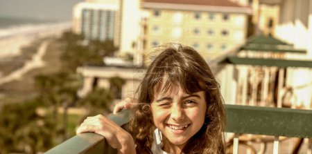Foto de Happy young girl smiling on holiday enjoying sea view from the hotel balcony in Myrtle Beach, South Carolina - Imagen libre de derechos