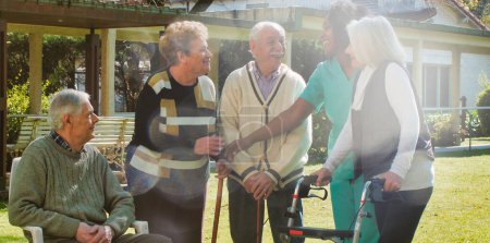 Photo for African nurse talking to two elderly retired couples outdoor in the rehab hospital garden. Happiness, rehabilitation and retirement concept. - Royalty Free Image