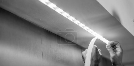 Foto de Me mudo a una casa nueva. Instalación de iluminación de diodos, cómo instalar la tira led para la iluminación correctamente en la barra de aluminio. - Imagen libre de derechos
