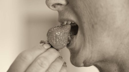 Foto de Una mujer comiendo fresas, detalle en la boca. - Imagen libre de derechos