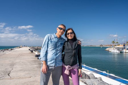 Téléchargez les photos : Un couple heureux en vacances, un port de ville en arrière-plan. - en image libre de droit