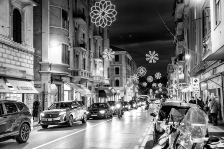Foto de Sanremo, Italia - 2 de enero de 2024: Las calles de la ciudad por la noche con los turistas. - Imagen libre de derechos