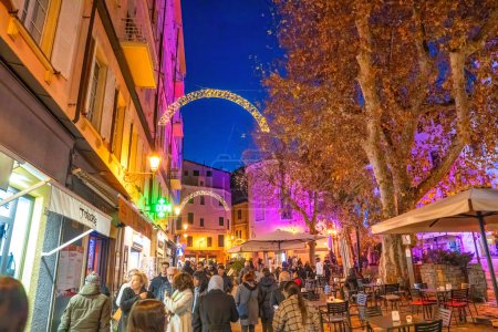 Foto de Sanremo, Italia - 30 de diciembre de 2023: Las calles de la ciudad por la noche con los turistas. - Imagen libre de derechos