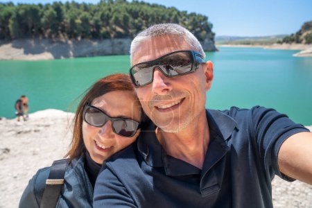 Téléchargez les photos : Un couple heureux se détendre le long d'un beau lac. - en image libre de droit