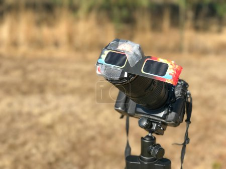Téléchargez les photos : Une caméra professionnelle protégée spéciale regardant le soleil lors d'une éclipse solaire sur un parc national. - en image libre de droit