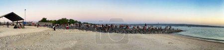 Photo for Bali, Indonesia - August 29, 2023: Tourists wait for the sunset on the airport beach. - Royalty Free Image