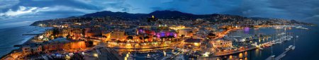 Luftaufnahme von Sanremo bei Nacht, Italien. Hafen- und Stadtgebäude.