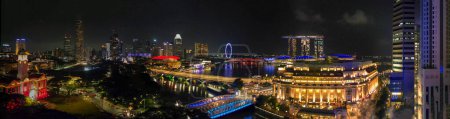 Aerial view of Boat Quay and Singapore skyline from Cavenagh Bridge at night.