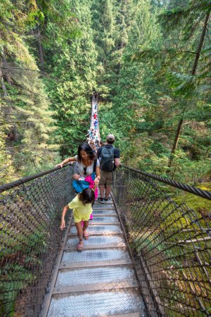 Foto de Vancouver - 11 de agosto de 2017: Puente colgante Twin Falls en Lynn Canyon con turistas en un día soleado. - Imagen libre de derechos