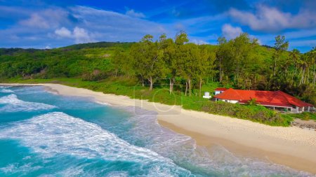 Grand Anse Beach in La Digue, Seychelles. Aerial view of red house along the coast.