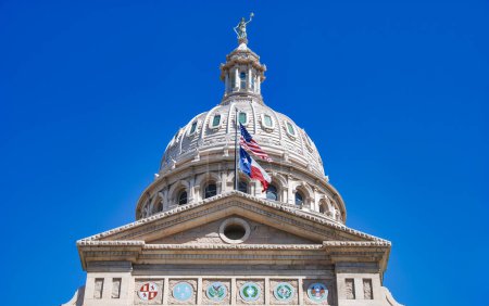 Photo for American and Texas state flags flying on the dome of the Texas State Capitol building in Austin. - Royalty Free Image