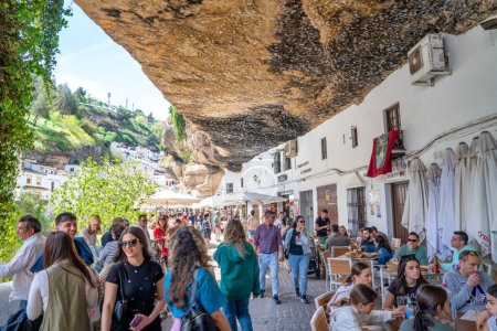 Photo for Setenil de las Bodegas, Spain - April 6, 2023: Typical Andalucian village with white houses and sreets with dwellings built into rock overhangs above Rio Trejo. - Royalty Free Image