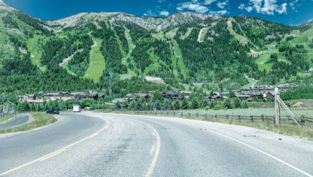 Téléchargez les photos : Vue imprenable sur Jackson Village avec route et montagnes en saison estivale, Wyoming. - en image libre de droit