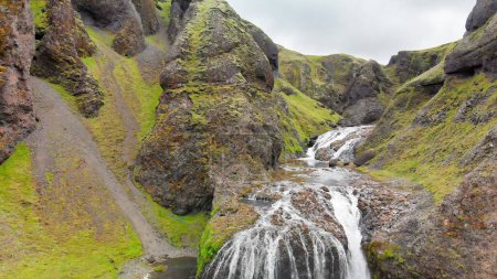 Téléchargez les photos : Vue aérienne de la belle cascade de Stjornarfoss par temps de pluie humide. - en image libre de droit