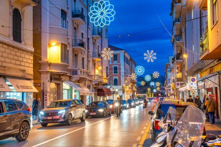 Foto de Sanremo, Italia - 2 de enero de 2024: Las calles de la ciudad por la noche con los turistas. - Imagen libre de derechos