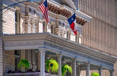 Foto de Banderas estatales de Estados Unidos y Texas ondeando frente al edificio Austin. - Imagen libre de derechos