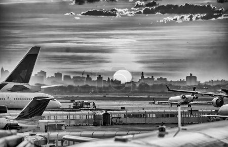 Backlit view of airplanes on the airport runway at sunset. Travel around the world concept.