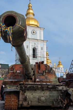 Foto de KYIV UKRAINE - 07 JANUARY 2023: Captured russian tank and other destroyed military vehicles during Russian invasion of Ukraine in 2022. St Michael's Golden-Domed Monastery on background. Editorial - Imagen libre de derechos