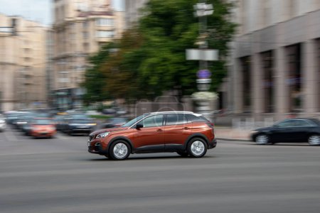 Foto de Ukraine, Kyiv - 2 August 2021: Orange Peugeot 3008 car moving on the street. Editorial - Imagen libre de derechos