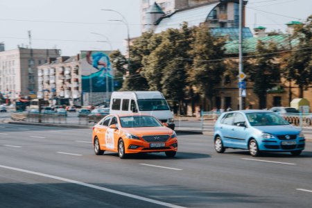 Foto de Ucrania, Kiev - 16 Jule 2021: Naranja Hyindai Sonata Taxi Bolt coche en movimiento en la calle. Editorial - Imagen libre de derechos