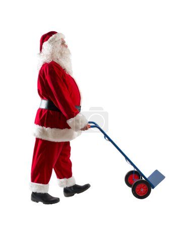 Téléchargez les photos : Santa claus pousse un chariot pour transporter des colis à livrer - en image libre de droit