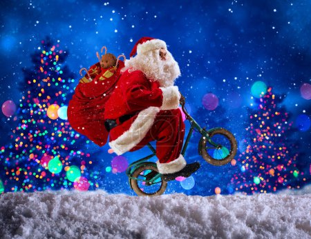 Photo for Santaclaus wheelie with bike to deliver fast xmas gifts - Royalty Free Image