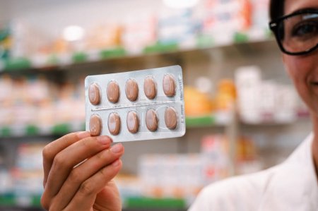 Foto de Farmacéutico muestra pastillas en ampollas en las farmacias - Imagen libre de derechos