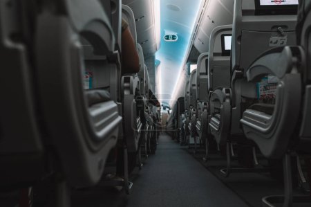 Foto de Interior del avión con pasillo y asientos grises - Imagen libre de derechos