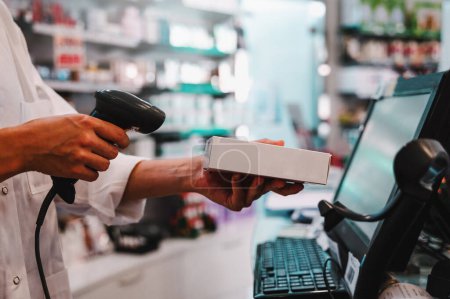 Téléchargez les photos : Pharmacist uses barcode reader to identify a drug - en image libre de droit