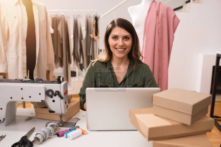 Photo for Seamstress works to new clothes ordered by online order - Royalty Free Image
