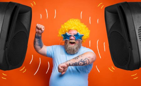 Foto de Hombre asombrado con barba, tatuajes y gafas de sol baila música - Imagen libre de derechos