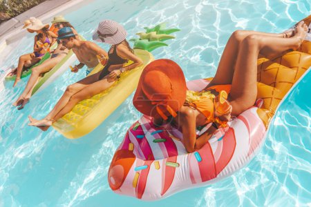 Téléchargez les photos : Groupe d'amis en maillot de bain dans la piscine bronzant - en image libre de droit