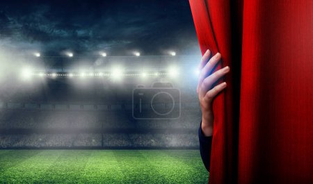 Foto de La mano está abriendo la cortina. El partido de fútbol está a punto de comenzar - Imagen libre de derechos
