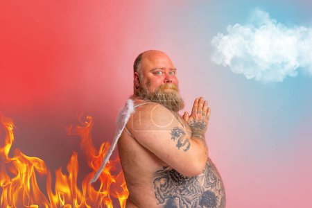 Foto de El hombre con barba, tatuajes y alas actúa como un ángel - Imagen libre de derechos