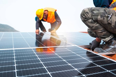 Foto de Trabajadores montan sistema con panel solar para electricidad y agua caliente - Imagen libre de derechos