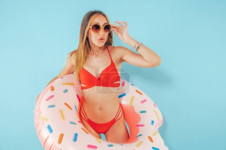 Foto de Mujer sorprendida con una rosquilla inflable lista para el verano - Imagen libre de derechos