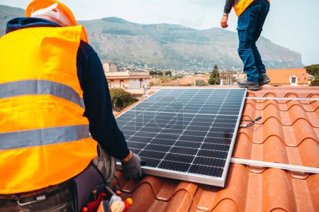 Téléchargez les photos : Les travailleurs assemblent le système avec le panneau solaire pour l'électricité et l'eau chaude - en image libre de droit