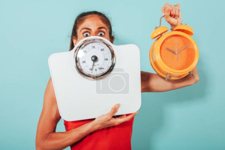 Foto de Mujer asustada tiene miedo de la medición de peso con la escala - Imagen libre de derechos