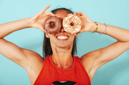 Photo for Funny woman uses a sweet donuts as glass - Royalty Free Image