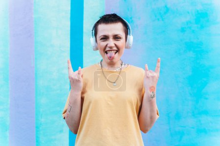 Foto de Mujer escucha música con auriculares blancos sonriendo - Imagen libre de derechos