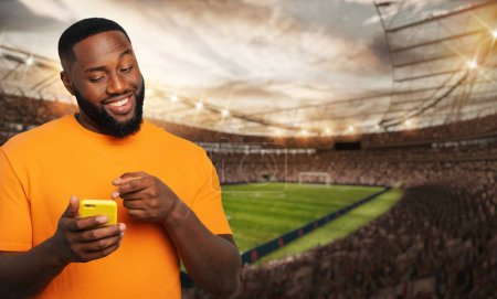 Téléchargez les photos : Homme regardant un match et pariant sur son téléphone portable - en image libre de droit