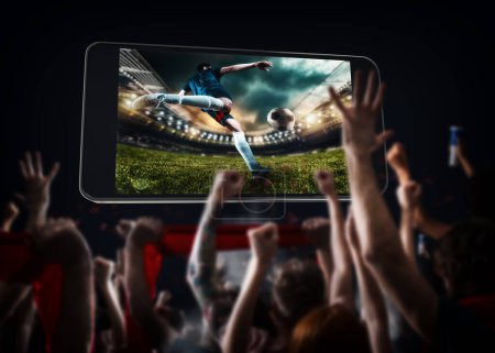 Foto de Jugadores de fútbol, celular y pelota en un estadio - Imagen libre de derechos