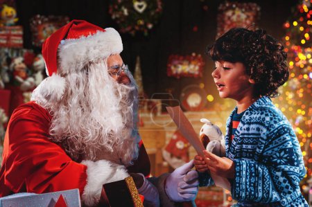 Téléchargez les photos : Père Noël écoute la demande de cadeaux d'un enfant pour Noël - en image libre de droit